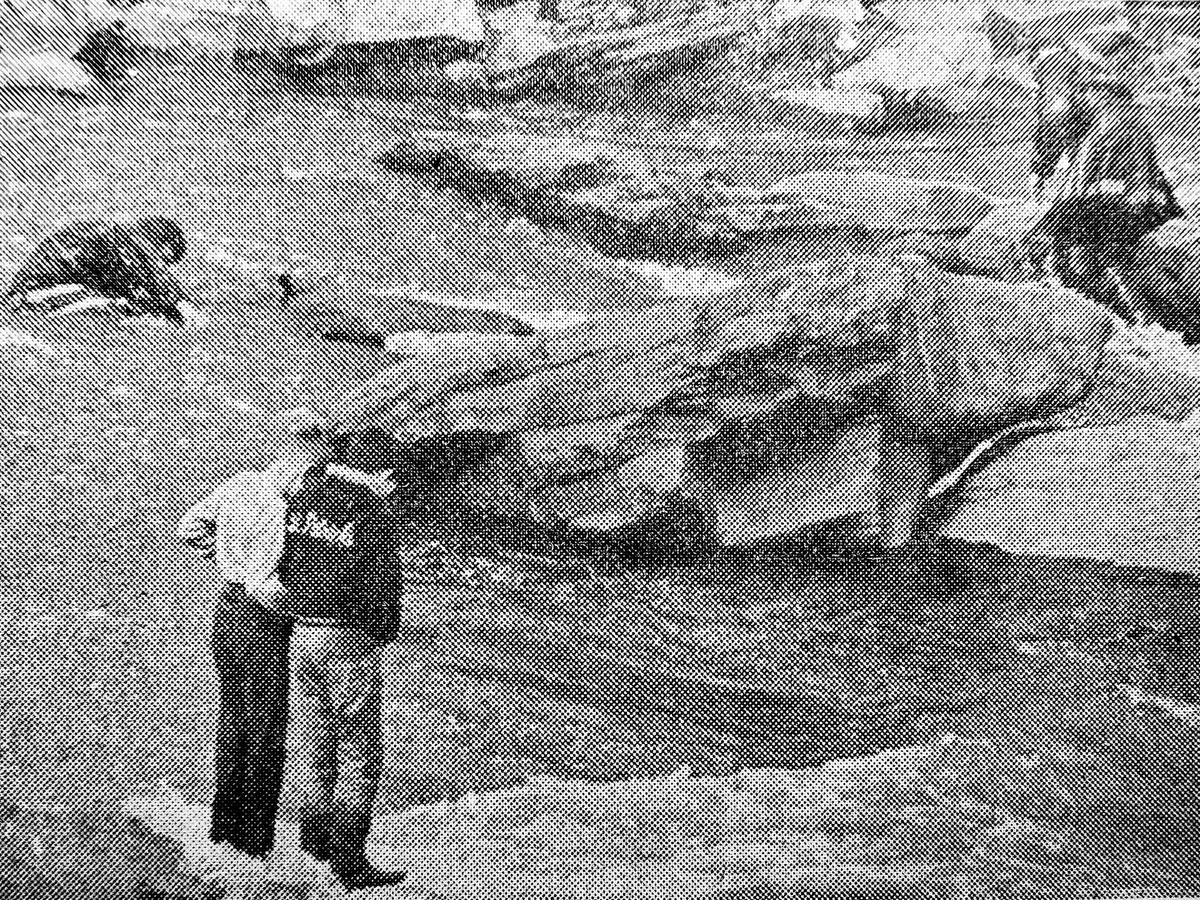 Fireman William Kirlin slips in rushing water, right, as he and fellow fireman attempt to reach boys stranded on rock.